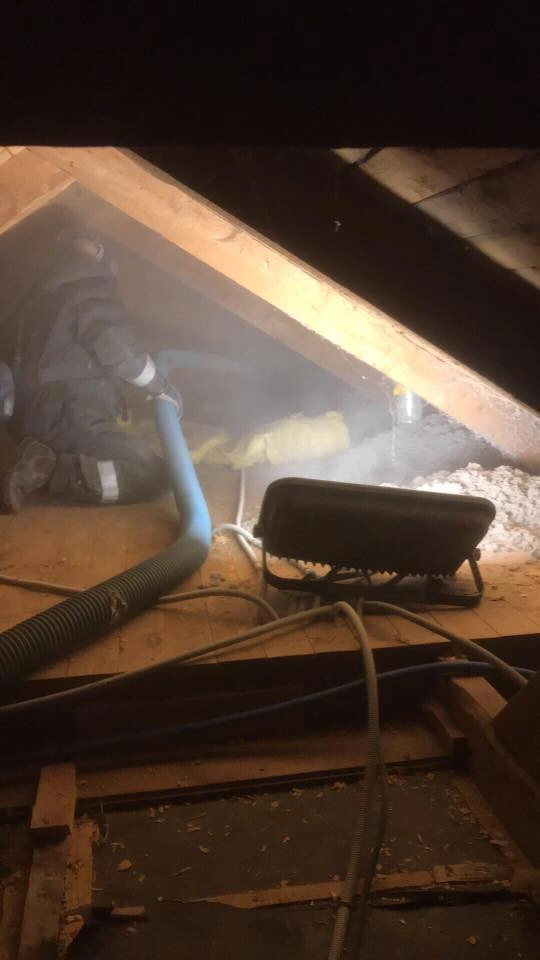 Cellulosaisolering blåses in i vindbjälklag med Isocell-maskin